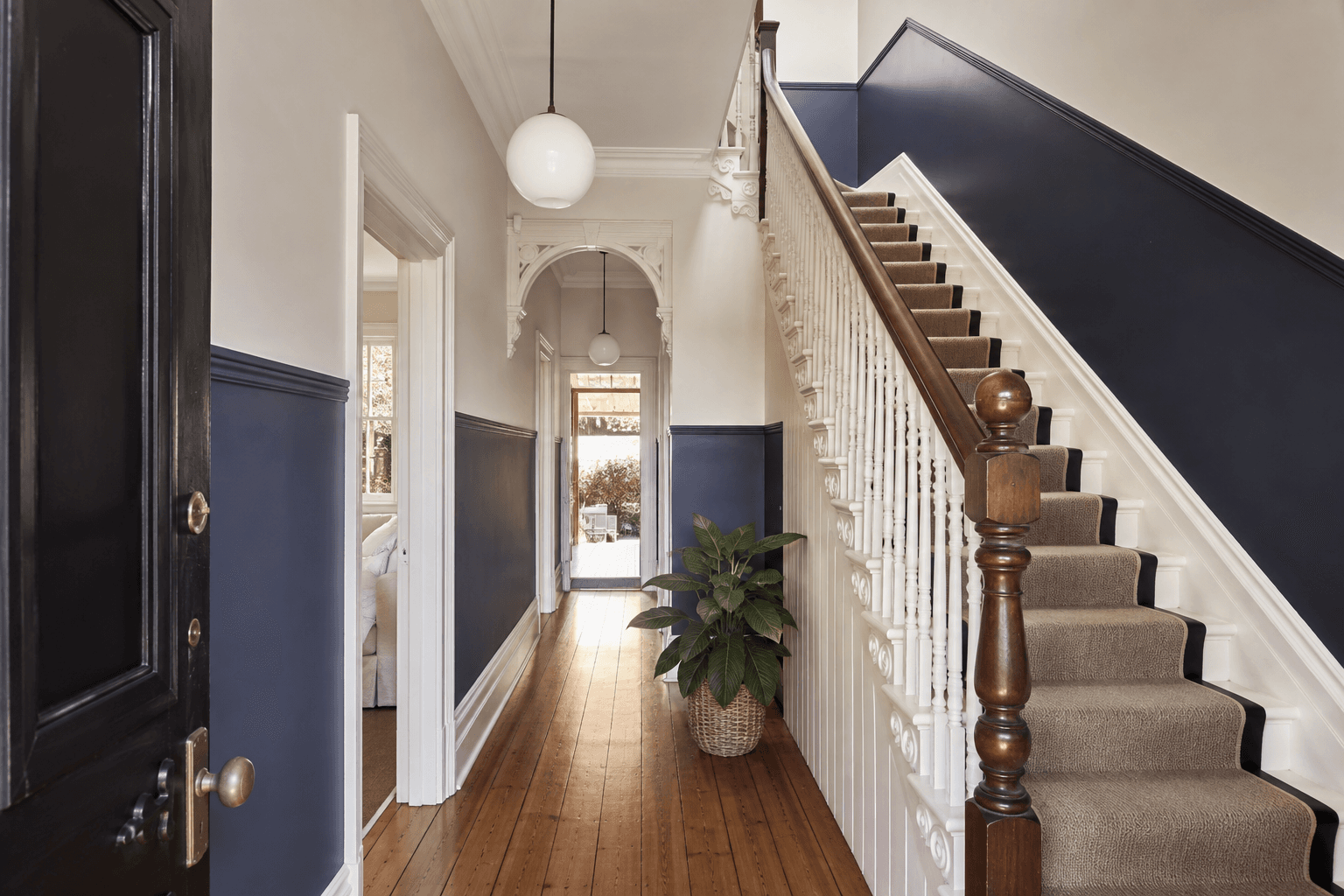 Navy and ivory painted stair hall with detailed timber trim